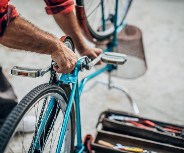 Man using tools to take of bike pedals